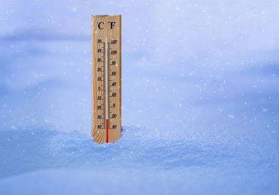 Close-up of information sign on snow