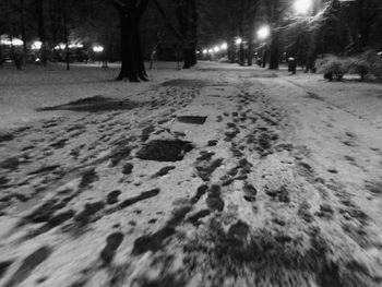 Footprints on snow covered field at night