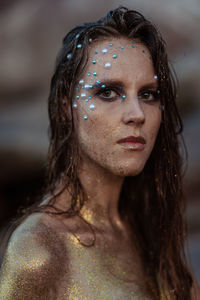 Portrait girl in gold glitter on the background of the stones