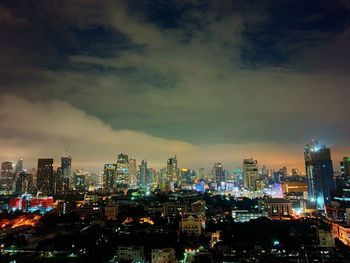 Illuminated buildings in city against sky at night