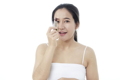 Portrait of a smiling young woman against white background