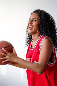 Portrait of a beautiful black women wearing basketball jersey holding basketball