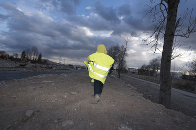 Rear view of man walking on street during winter