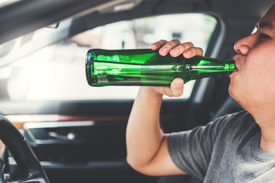 Midsection of man drinking beer in glass