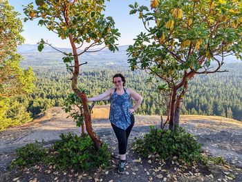 Portrait of mature woman standing against trees