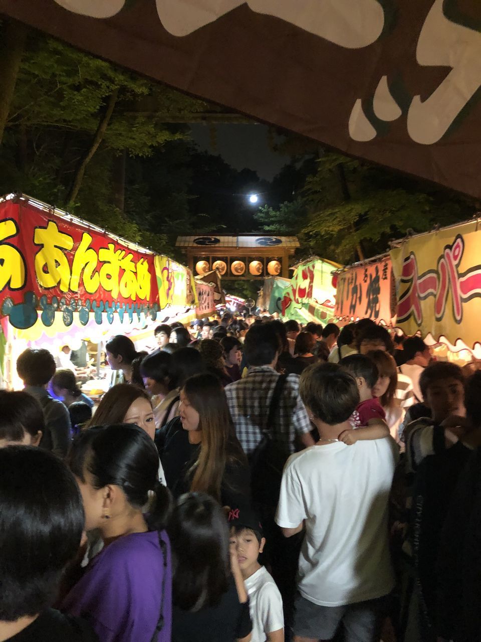 GROUP OF PEOPLE AT ILLUMINATED MARKET