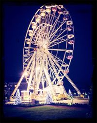 Low angle view of ferris wheel against sky at night