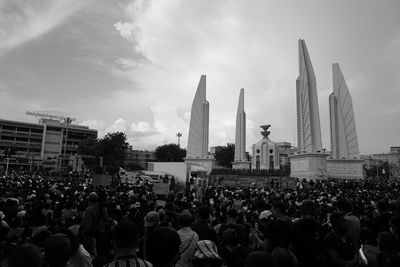 Group of people in city against sky