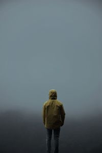 Rear view of man standing on snow covered landscape