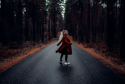 Full length of woman on road in forest