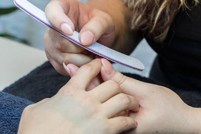 Woman giving shape for customer fingernail