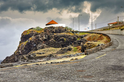 Road amidst rocks against sky