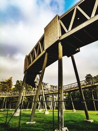 Low angle view of bridge on field against sky