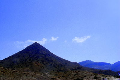 Scenic view of mountains against blue sky