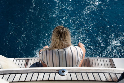 Rear view of woman sitting in water