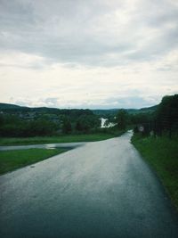 Empty road against cloudy sky