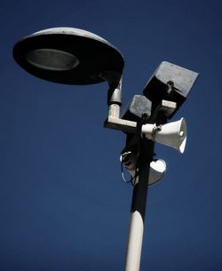 Low angle view of lamp post against clear blue sky