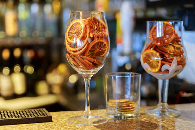 Citrus fruit slices in wineglasses on bar counter