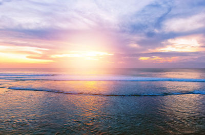 Sunset at the ocean with water ripple and small waves in the dark colors