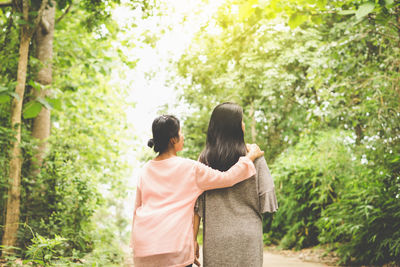 Rear view of couple standing against trees