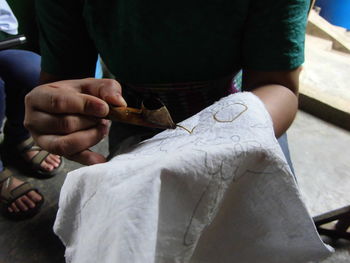 Midsection of woman making design on textile