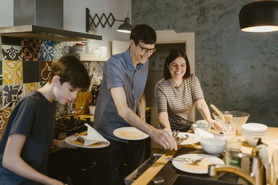 Female friends toasting drinks at home