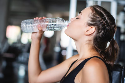 Portrait of woman drinking water from bottle