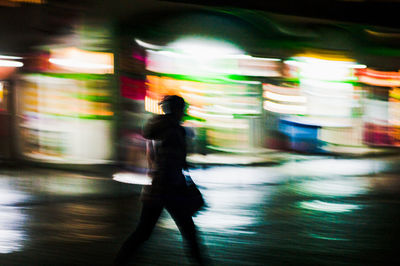 Blurred motion of man walking in illuminated underground