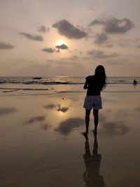 Full length of man standing on beach during sunset