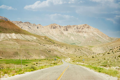 Mountains with countryside road, foliage, grass and cloudy sky in mazandaran province, iran