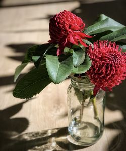 Close-up of red rose in glass vase on table