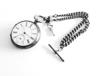 Close-up of pocket watch on white surface