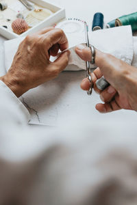 Cropped hands of woman cutting clothes