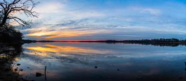 Scenic view of lake against sky at sunset