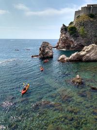 Scenic view of rocks in sea against sky