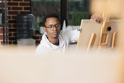 Portrait of young man sitting on table