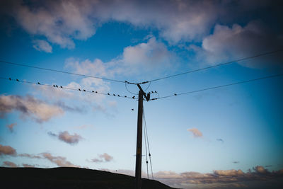 Low angle view of electricity pylon against sky