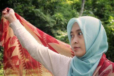 Portrait of woman holding scarf