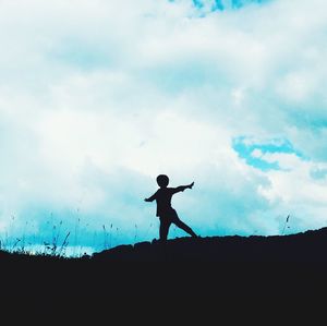 Low angle view of silhouette man standing against sky