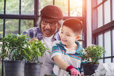 Father and son on potted plant at home