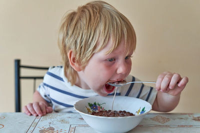 Close-up of boy eating food at home