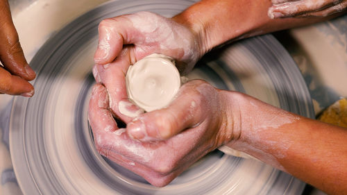 Close-up of a potter working on a wheel. an open class is in progress