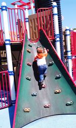 Full length of boy standing on slide in playground