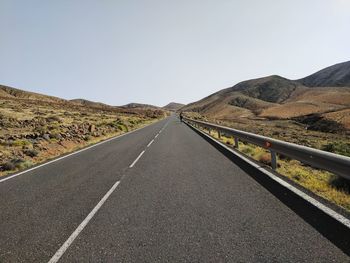 Road by mountain against clear sky