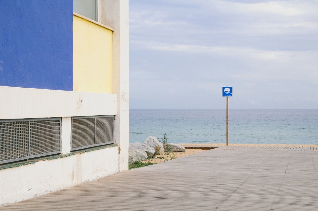 sea, horizon over water, sky, beach, water, built structure, architecture, blue, shore, protection, tranquility, tranquil scene, sand, day, building exterior, cloud, nature, safety, cloud - sky, no people