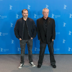 Portrait of friends standing against blue wall