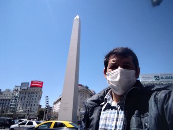 Portrait of man in city against clear sky