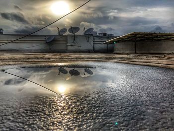 Reflection of building in puddle during sunset