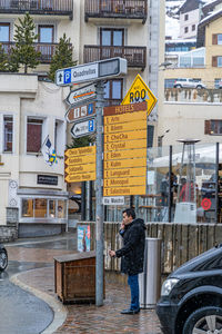 Man standing on street against buildings in city