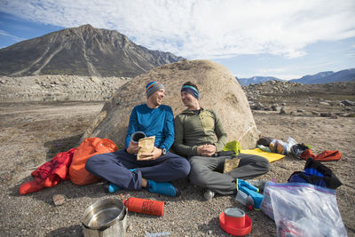 Climbing partners share a laugh during mealtime at campsite.